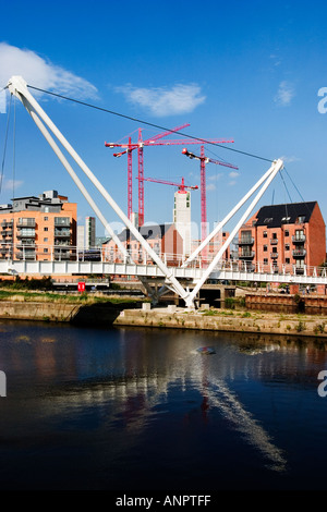 Neue Fußgängerbrücke am Clarence Dock mit der Fortsetzung der Bauarbeiten hinter in Leeds, West Yorkshire, England Stockfoto