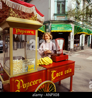 Attraktives Mädchen DANZIG POPCORN VERKÄUFER 1990 Popcorn und Banane Verkäufer, stellt mit ihren bunt bemalten Händler Warenkorb, im Zentrum von Danzig, Polen Stockfoto