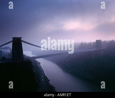 Clifton Suspension Bridge über den Fluss Avon in der Avon Gorge im Winternebel kurz nach Sonnenuntergang. Bristol, England Stockfoto