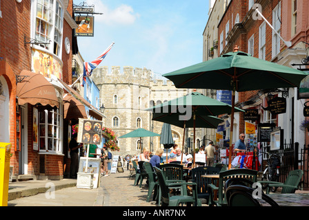 Church Street in Windsor gegenüber der Burg mit Straßencafés und Geschäften. Stockfoto