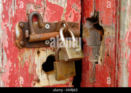 Vorhängeschloss und Hasp und Grundnahrungsmittel, rot gemalte Hütte Tür zu sichern Stockfoto