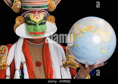 Porträt des Kathakali Tanz Darsteller hält einen Globus Stockfoto