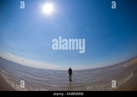 Ein weiterer Ort von Antony Gormley. Rückansicht einer gusseisernen Skulptur mit einem Bauhut am Crosby Beach, aufgenommen mit einer Fisheye-Linse. Stockfoto