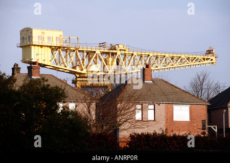 Die Riesen-Werft-Kran überragt 1930er Jahren Wohnungsbau in-Furness, Cumbria Stockfoto