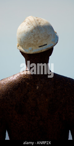 Gusseiserner Mann mit Baumütze, Teil von Antony Gormley's Another Place in Crosby Beach, Merseyside. UK Stockfoto