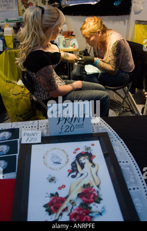 Junge Dame mit ihrem Schaden tätowiert auf der ersten London international Tattoo convention Stockfoto