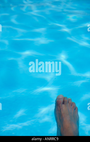 MODELL FREIGEGEBEN SCHUSS VON MANS FUß GETAUCHT IN EINEM SCHWIMMBAD Stockfoto