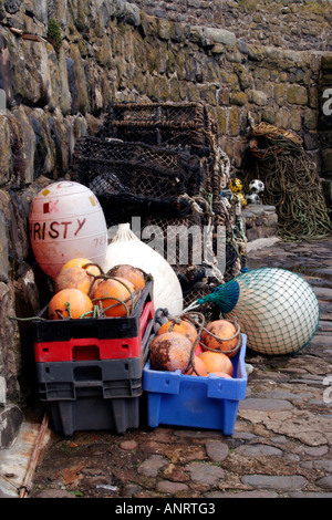 Bojen und schwimmt gestapelt gegen die Hafenmauer, Clovelly, Devon, England, UK Stockfoto