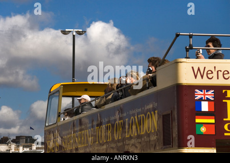 Touristen auf einer Sightseeing-Tour durch London fotografieren aus dem offenen Oberdeck des traditionellen Doppeldeckerbus Stockfoto