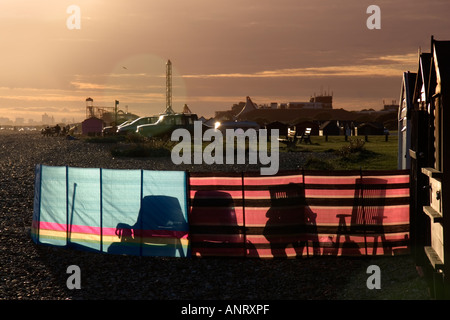 Urlauber, die Silhouette gegen Colouful Windschutz auf einem Kiesstrand in Hayling Island Hampshire England UK Stockfoto