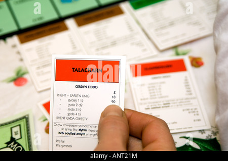Person spielen walisische Sprache Monopoly Brettspiel Cymraeg Wales - Nahaufnahme von Hand mit TALACHARN Eigenschaft Karte (Cerdyn Eiddo Stockfoto