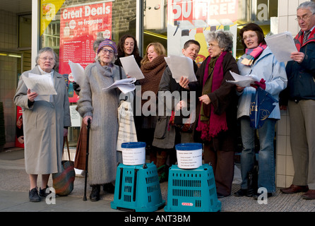 Eine Gruppe von 7 sieben Frauen und ein Mann singen Weihnachtslieder auf der Straße sammeln Geld für wohltätige Zwecke Aberystwyth Wales UK Stockfoto