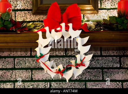 Ein Kamin Mantel dekoriert zu Weihnachten mit einem festlichen Metall Gans Kranz. USA. Stockfoto