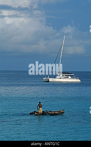 Fischer legt in seinem ausgegraben Auslegerkanu moderne Yacht über Nungwi nördlichen Spitze von Sansibar Tansania Ostafrika Stockfoto