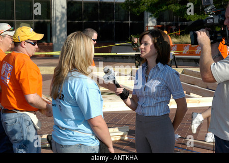TV-News-Reporter interviewt Freiwilligen, die ein Heim für obdachlose Familien unter dem Haus für die Menschheit-Projekt bauen Stockfoto