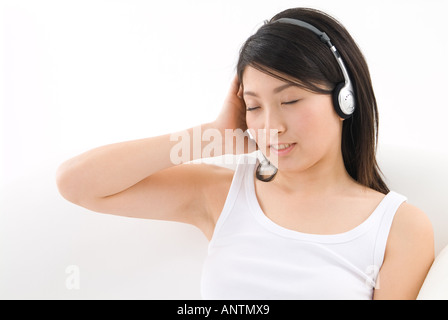 Junge Frau trägt Kopfhörer Stockfoto