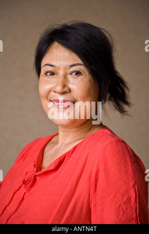Applying asiatischen orientalischer Chinesin in orange Kleid lächelnd Blick in die Kamera Peking China JMH2965 Stockfoto