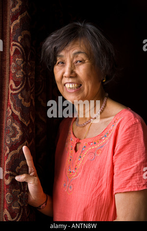 Applying asiatischen orientalischer Chinesin in orange Kleid lächelnd Blick in die Kamera Peking China JMH2969 Stockfoto