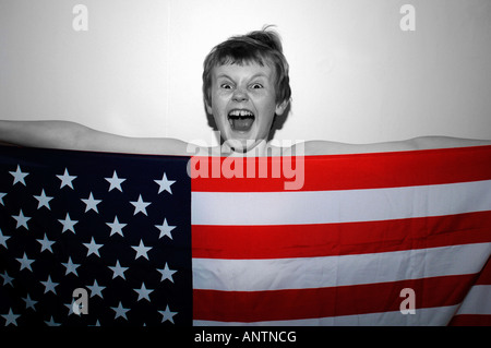 Ein 13 Jahre alter Junge hinter der amerikanischen Stars & Streifen-Flagge, die er in der Hand. Stockfoto