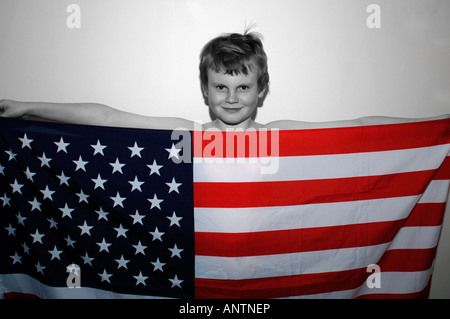 Ein 13 Jahre alter Junge hinter der amerikanischen Stars & Streifen-Flagge, die er in der Hand. Stockfoto