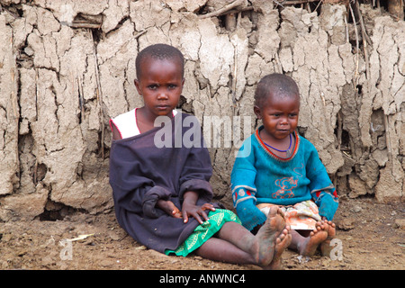 Maasai-Kinder-Massai-Dorf zeigt Schlamm-Hütte aus Stöcken und Kuhmist Masai Mara National Nature Reserve Kenya Stockfoto