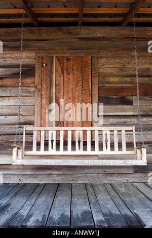 Hängenden hölzernen Sitzbank auf der Veranda des alten Holzhauses. Stockfoto