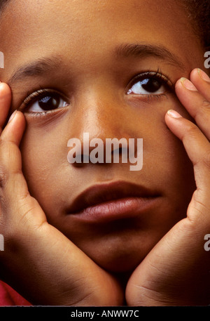 Traurig Afro-Karibischen 8 Jahre, 10 Jahre junge mit dem Kopf in seinen Händen Stockfoto