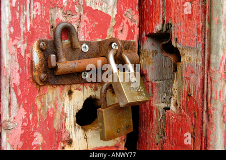 Vorhängeschloss und Hasp und Grundnahrungsmittel, rot gemalte Hütte Tür zu sichern Stockfoto