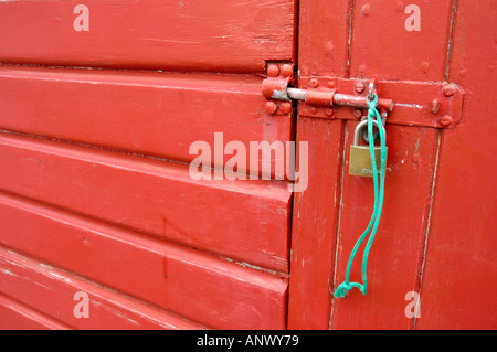 Vorhängeschloss und Hasp und Grundnahrungsmittel, rot gemalte Hütte Tür zu sichern Stockfoto