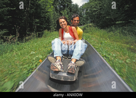 junges Paar auf eine Allwetter-Rodelbahn Rutsche, Austria, Windischgarsten Stockfoto