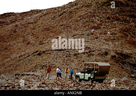 Afrika, Namibia, Damaraland. Safari-Jeep geparkt in Felslandschaft Damaraland Landschaft, Touristen. Stockfoto