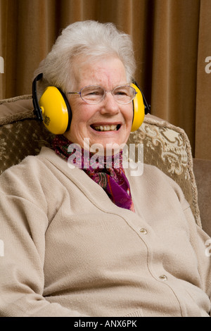 Ältere Dame tragen Ohr ^ Verteidiger und lachen Stockfoto