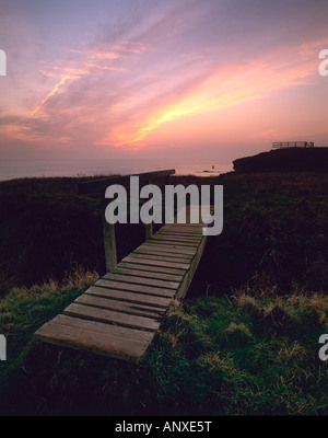 einer alten klapprigen hölzernen Fußgängerbrücke bei Sonnenuntergang in Compton Bay auf der Isle Of Wight gehen über einen kleinen Bach auf der Klippe Küste Stockfoto