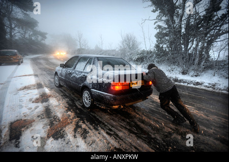EIN AUTO STECKEN IN DEN SCHNEEBEDECKTEN BEDINGUNGEN IN DER NÄHE VON WOTTON UNTER EDGE GLOUCESTERSHIRE UK Stockfoto