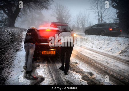 EIN AUTO STECKEN IN DEN SCHNEEBEDECKTEN BEDINGUNGEN IN DER NÄHE VON WOTTON UNTER EDGE GLOUCESTERSHIRE UK Stockfoto