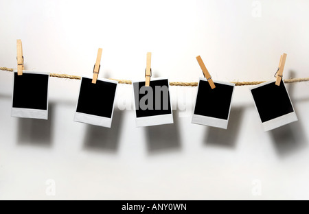 Krummen alten Polaroid Film Rohlinge hängen an einem Seil durch Wäscheklammern gehalten Stockfoto