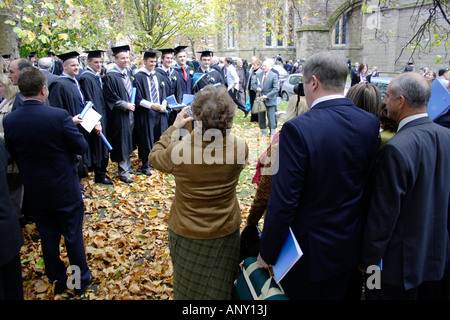 Absolventen aus Worcester Universität mit ihren Fotografien am Abschlusstag außerhalb Worcester Cathedral Stockfoto