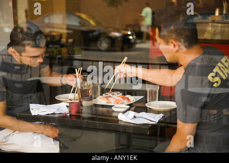 ILLINOIS-Chicago-zwei Männer benutzen Stäbchen Sushi asiatische Küche im Restaurant Blick durch Fenster North Halsted Bereich Essen Stockfoto