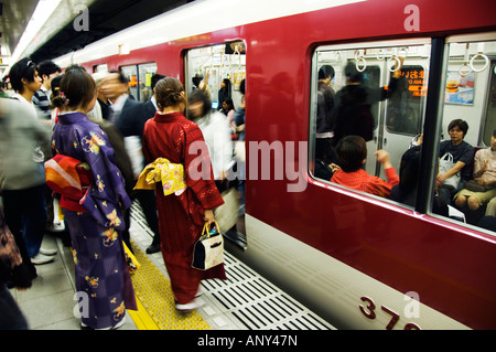 Japan, Insel Honshu, Kyoto Präfektur, Stadt Kyoto, Kyoto Station. Junge Frauen tragen Kimonos, kommt man auf einen Zug warten. Stockfoto