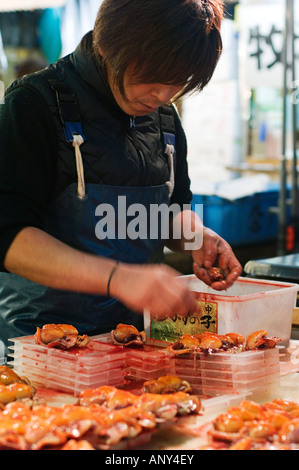 Japan, Insel Honshu, Tokyo, Tsukiji-Fischmarkt. Ein Arbeiter, der Zubereitung von Fisch zu verkaufen. Stockfoto