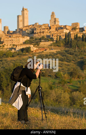 Italien; Toskana; San Gimignano. Ein Tourist Fotos San Gimignano mit seinen charakteristischen mittelalterlichen Türmen. Stockfoto