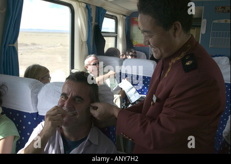 Personal verwaltet Sauerstoff für Passagiere auf dem Tangula Express / Sky-Train von Golmud, Qinghai Provinz, China, nach Lhasa, Tibet Stockfoto