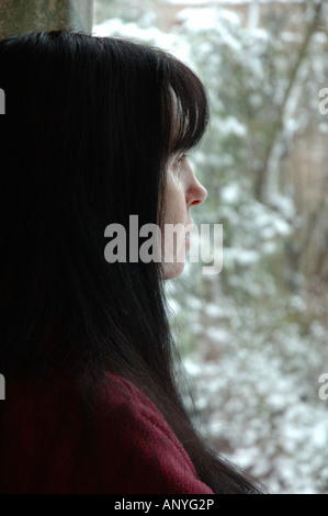 Großbritannien, England, Frau Blick aus Fenster im winter Stockfoto