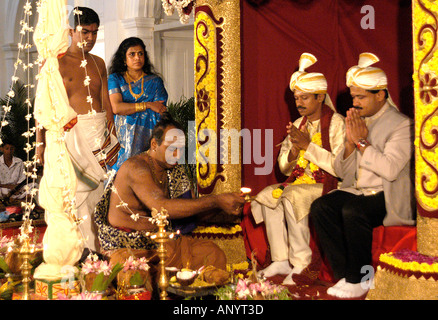 Traditionelle hinduistische Hochzeitszeremonie auf einer kunstvollen Bühne mit einem Priester, der heilige Rituale für die Braut und den Bräutigam Sri Lanka Ceylon vorführt. Stockfoto