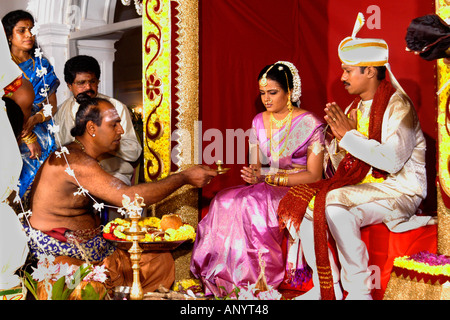 Traditionelle hinduistische Hochzeitszeremonie auf einer kunstvollen Bühne mit einem Priester, der heilige Rituale für die Braut und den Bräutigam Sri Lanka Ceylon vorführt. Stockfoto