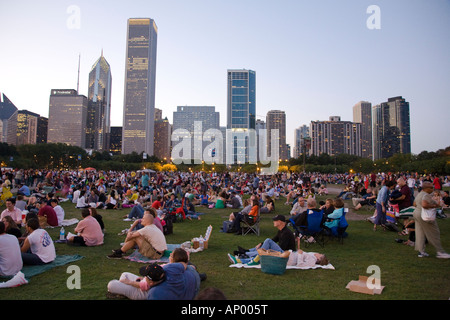 ILLINOIS Chicago Masse der Leute sitzen im Grant Park Petrillo Freilichtbühne für Jazz Festival Stadt Skyline in der Abenddämmerung Stockfoto