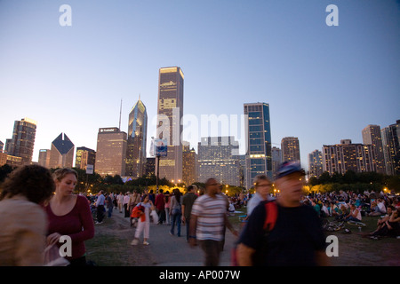 ILLINOIS Chicago Masse der Leute sitzen im Grant Park Petrillo Freilichtbühne für Jazz Festival Stadt Skyline in der Abenddämmerung Stockfoto