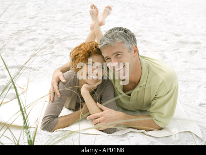 Älteres Paar gemeinsam auf Sand liegend Stockfoto