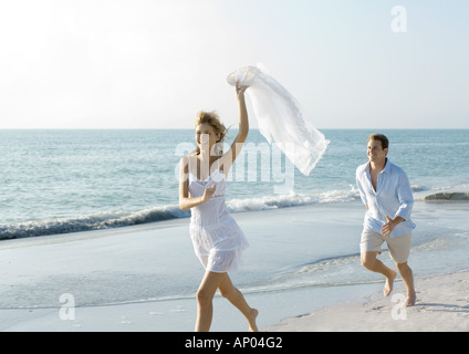 Paar am Strand, Mann jagt Frau Stockfoto