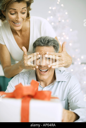 Frau Mann mit Weihnachtsgeschenk überraschen Stockfoto